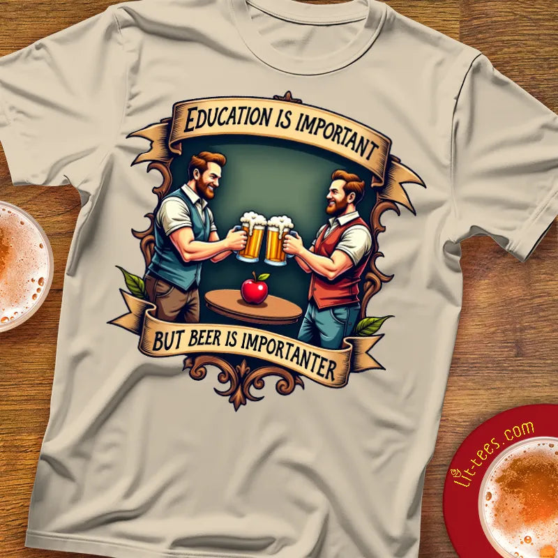 T-shirt with graphic design of two men holding beer mugs and text 'Education is important but beer is importanter' on a wooden surface.