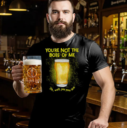 Man in a bar holding a beer and wearing a black t-shirt with a beer graphic and text saying 'You're not the boss of me... oh wait, yes you are
