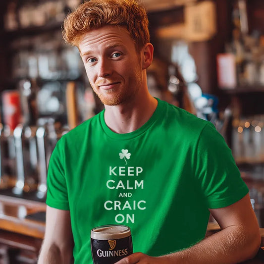 Man wearing a green t-shirt with 'Keep Calm and Craic On' holding a pint of Guinness in a bar setting.