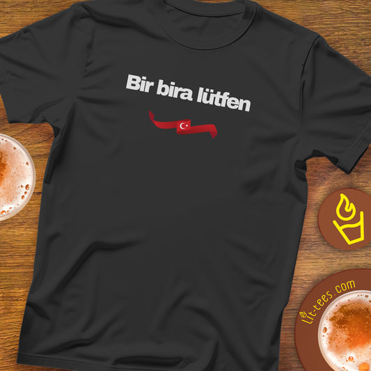 Black t-shirt with white text saying One Beer Please in Turkish on a bar table
