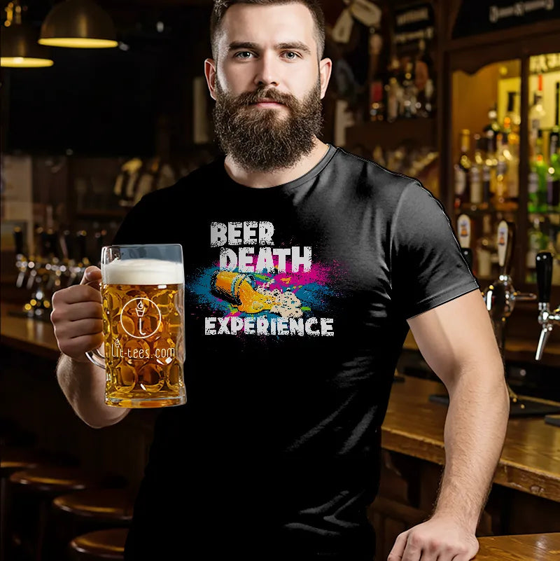Man holding a beer mug wearing a black t-shirt with colorful text reading 'Beer Death Experince' in a bar setting