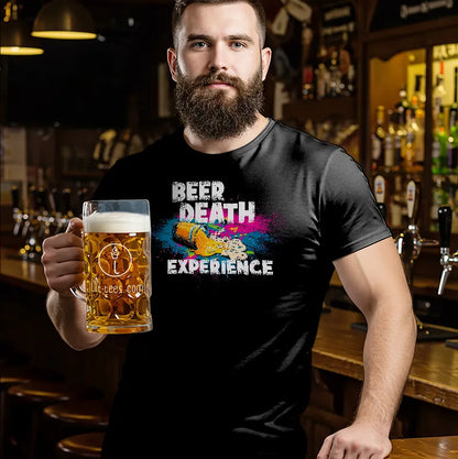 Man holding a beer mug wearing a black t-shirt with colorful text reading 'Beer Death Experince' in a bar setting