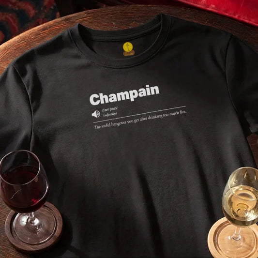 Black t-shirt with 'Champain' definition print and wine glasses on a wooden bar surface.