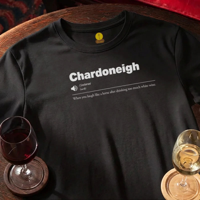 Black t-shirt with 'Chardoneigh' definition and wine glasses on a wooden bar surface.