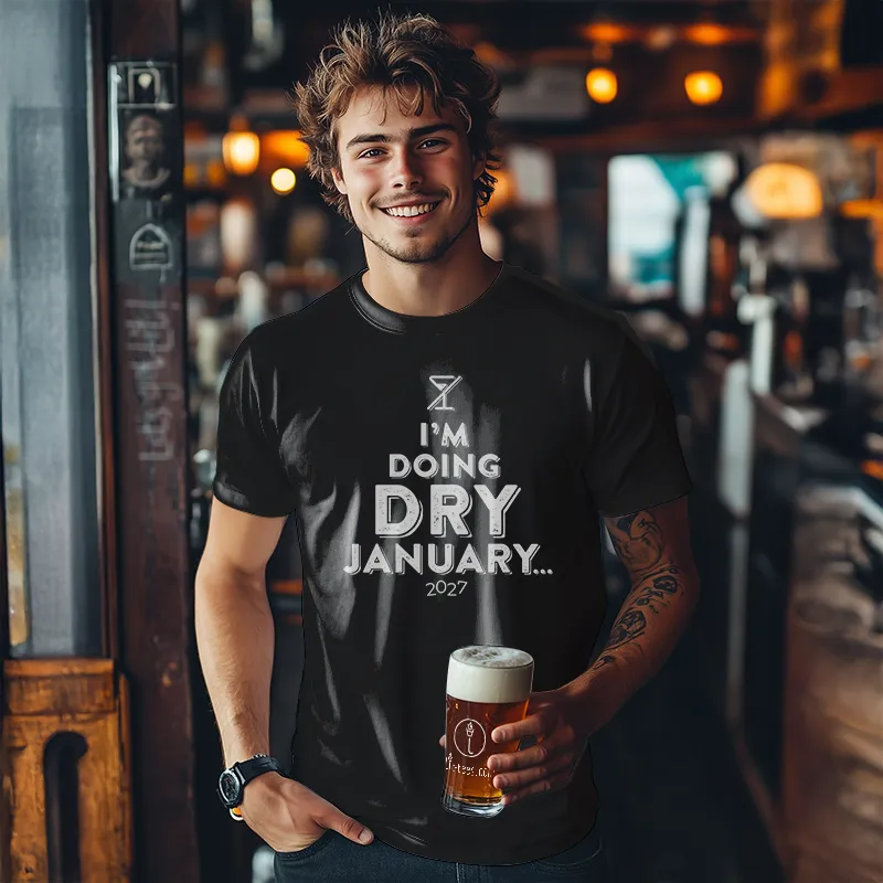 Man holding a beer in a bar wearing a 'I'm doing Dry January... 2027' t-shirt.