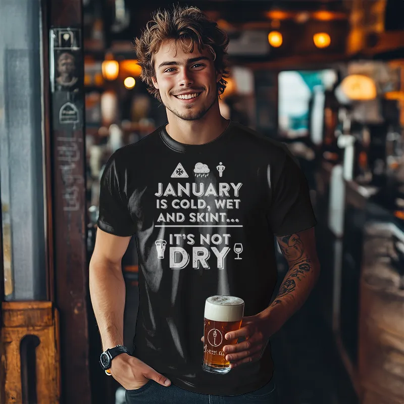 Man holding a beer in a bar wearing a black t-shirt with text saying January is cold, wet and skint... it's not dry