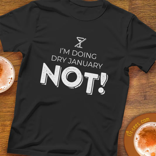 Black t-shirt with 'I'm doing Dry January Not!' text on a wooden bar table with drinks