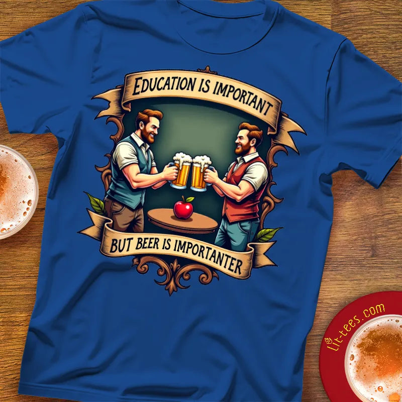 Blue t-shirt with graphic of two men holding beer mugs and text 'Education is important but beer is importanter' on a wooden surface.