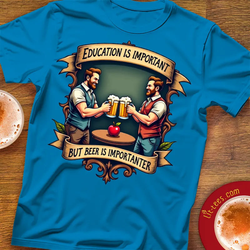 Blue t-shirt with graphic of two men holding beer mugs and text 'Education is important but beer is importanter' on a wooden surface.