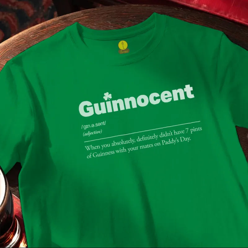 Green t-shirt with 'Guinnocent' text on a wooden bar surface