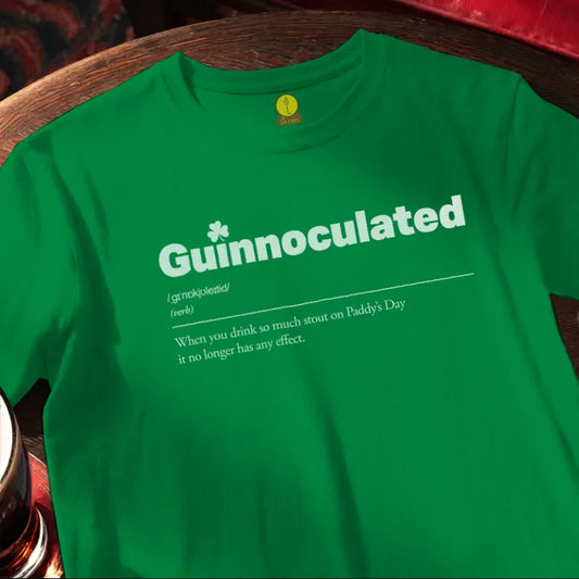 Green t-shirt with 'Guinnoculated' text on a wooden bar surface