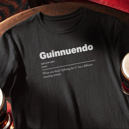 Black t-shirt with 'Guinnuendo' definition text on a wooden bar table