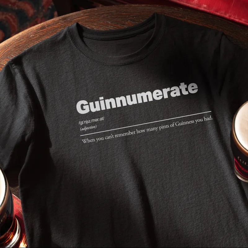 Black t-shirt with 'Guinnumerate' text on a wooden bar table