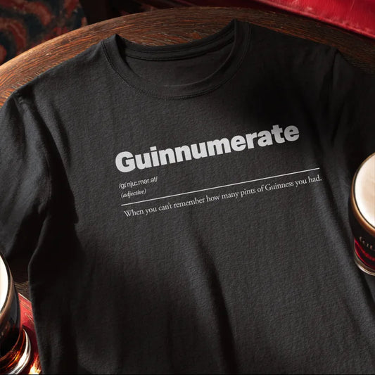 Black t-shirt with 'Guinnumerate' text on a wooden bar table
