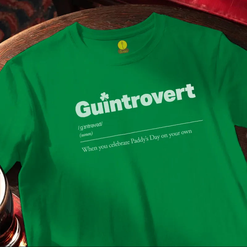 Green t-shirt with 'Guintrovert' text on a wooden bar surface