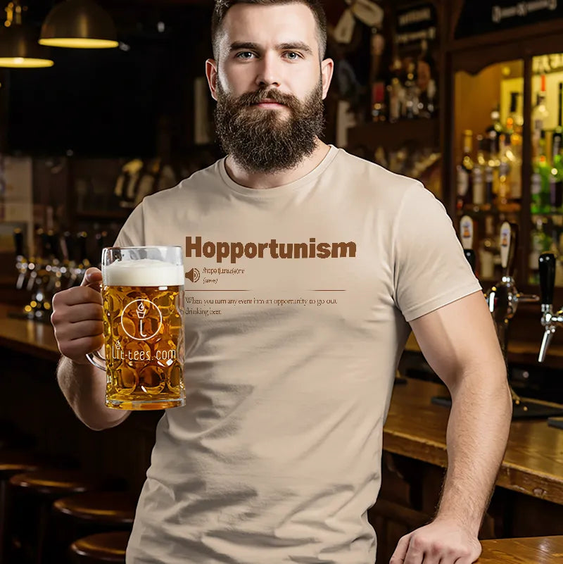 Man in a bar wearing a t-shirt with Hopportunism' text, holding a beer glass.