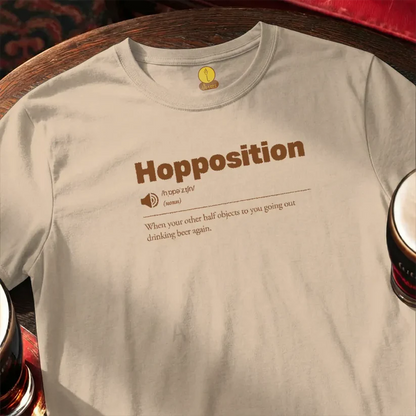 Beige t-shirt with 'Hopposition' text and beer glasses on a wooden surface