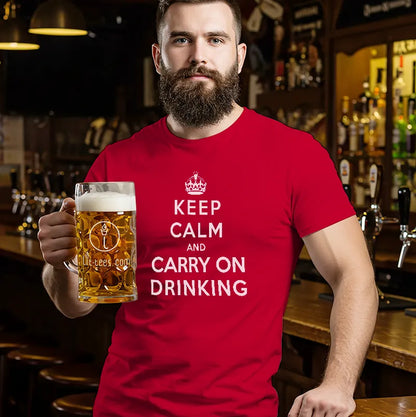 Man in bar holding a beer and wearing a red t shirt with text saying Keep Calm and Carry on Drinking