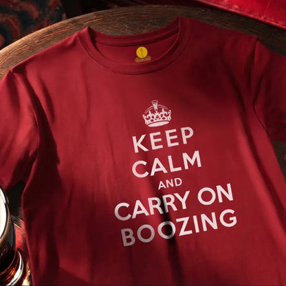 Red T Shirt with text saying Keep Calm and Carry on Boozing on a wooden bar table
