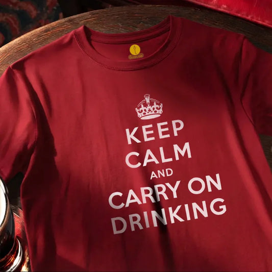 Red T shirt with text saying Keep Calm and Carry on Drinking on a wooden bar table