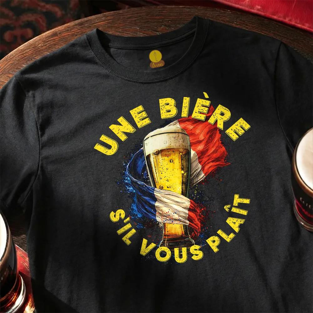 Black t-shirt with a beer graphic and text on a wooden surface. French: Une bière, s'il vous plaît