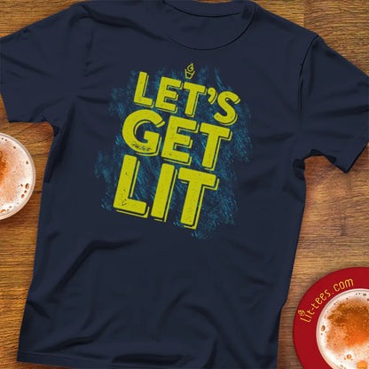 Navy blue t-shirt with 'LET'S GET LIT' text on a wooden surface with drinks.
