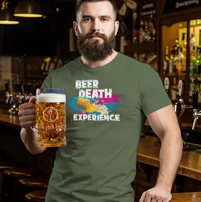 Man holding a beer mug wearing a green t-shirt with colorful text reading 'Beer Death Experience' in a bar setting