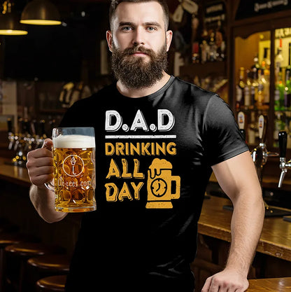 Man holding a beer mug wearing a black t-shirt with 'DAD Drinking All Day' text in a bar setting.