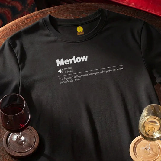 Black t-shirt with 'Merlow' definition print on a wooden bar table with wine glasses.