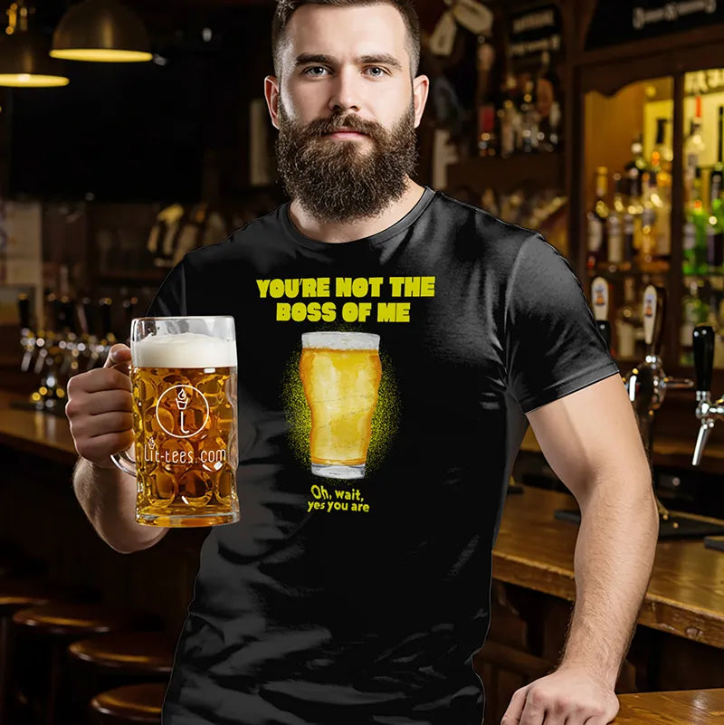 Man in bar holding a beer mug wearing black t-shirt with a beer pint graphic and text saying 'You're not the boss of me... oh wait, yes you are'
