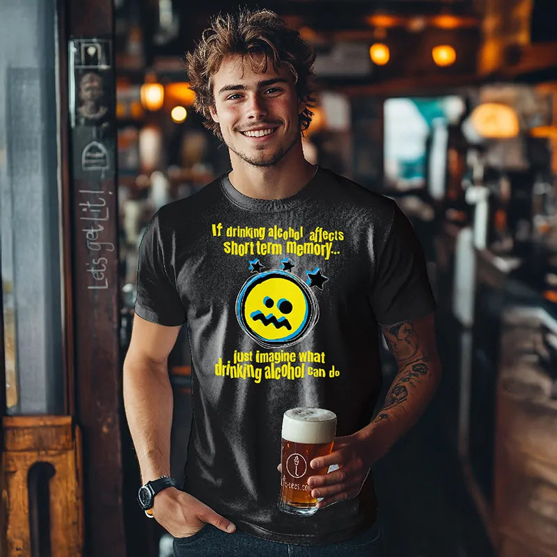 Man in bar hoding a beer and wearing black t-shirt with yellow graphic and text saying 'If drinking alcohol affects short term memory just imagine what drinking alcohol can do'