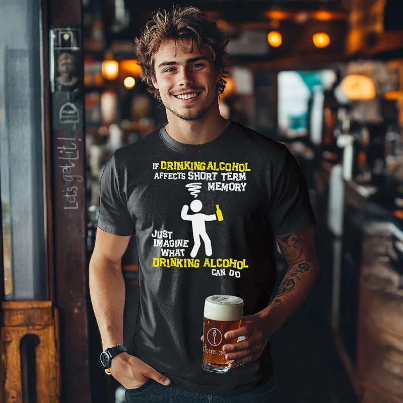 Man in bar holding a beer wearing a black t-shirt with humorous alcohol-themed graphic and text saying 'If drinking alcohol affects short term memory just imagine what drinking alcool can do'
