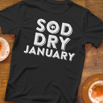 Black t-shirt with 'SOD DRY JANUARY' text on a wooden surface with drinks.