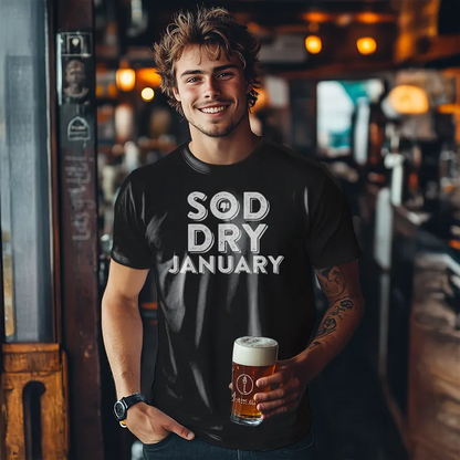 Man holding a beer in a bar wearing a 'Sod Dry January' shirt